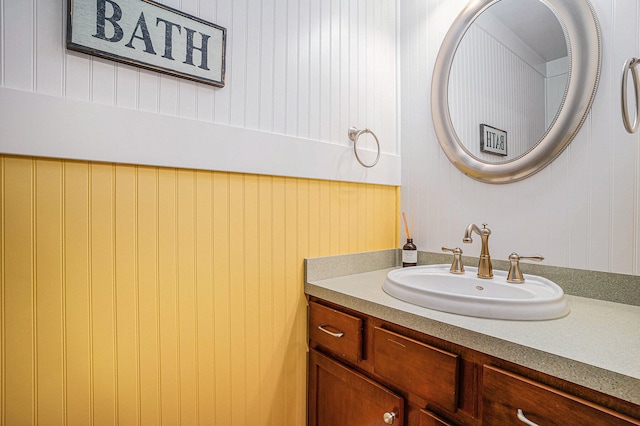 bathroom with vanity and wood walls