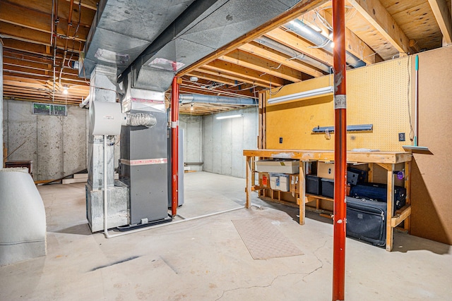 basement featuring a workshop area and heating unit