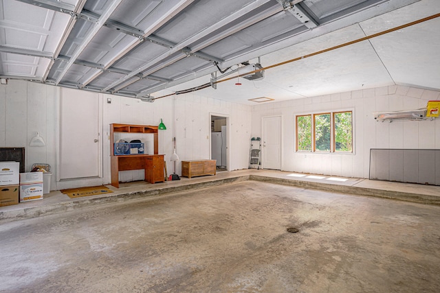 garage featuring stainless steel fridge and a garage door opener