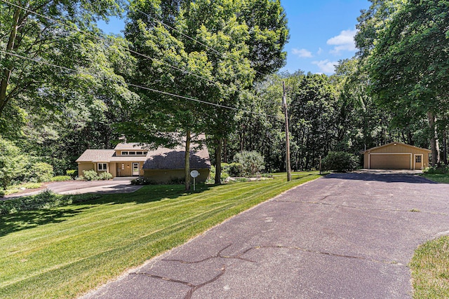 view of front of property with a garage, an outbuilding, and a front yard