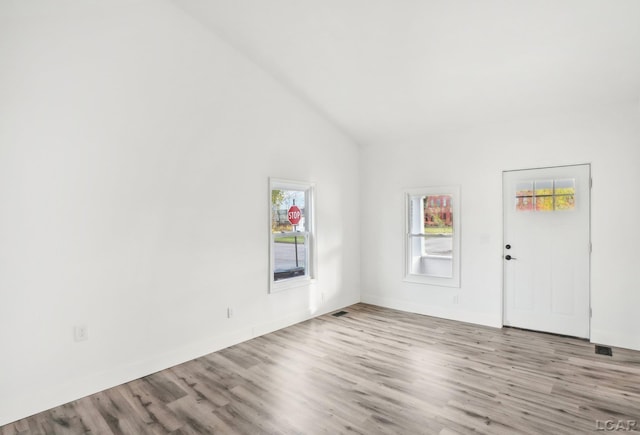 interior space featuring high vaulted ceiling and light hardwood / wood-style floors