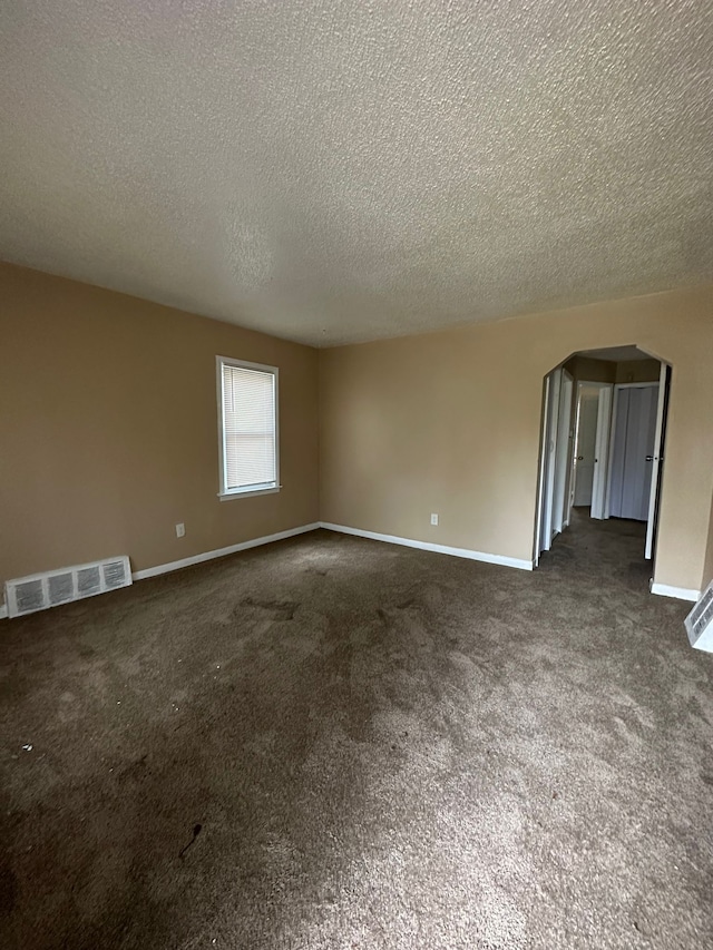 carpeted empty room featuring a textured ceiling