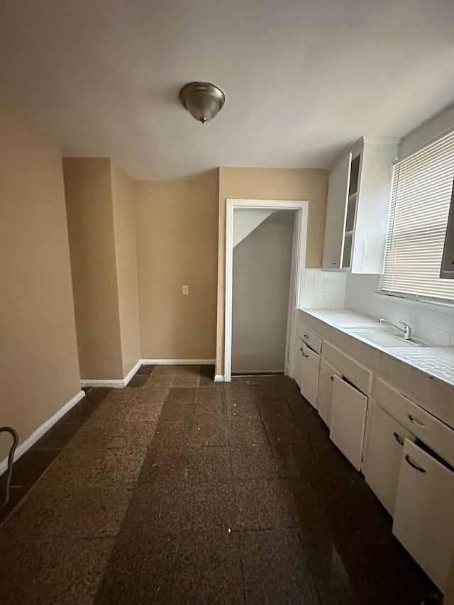 kitchen featuring white cabinets, decorative backsplash, and sink