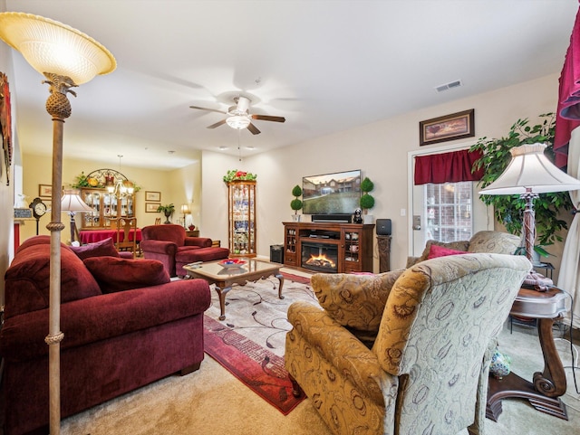 living room with carpet and ceiling fan with notable chandelier