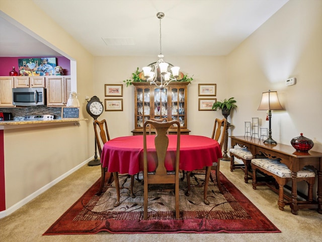 carpeted dining area with an inviting chandelier