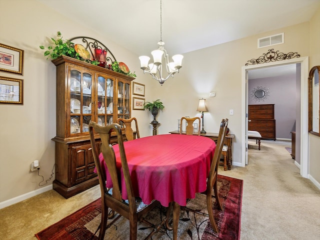 carpeted dining space with a chandelier