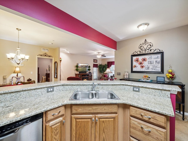 kitchen with sink, light stone counters, stainless steel dishwasher, light carpet, and ceiling fan with notable chandelier