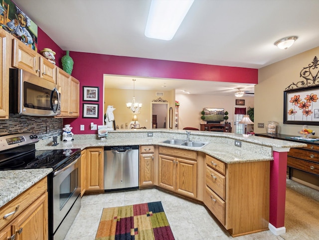 kitchen with hanging light fixtures, light stone counters, a notable chandelier, kitchen peninsula, and appliances with stainless steel finishes