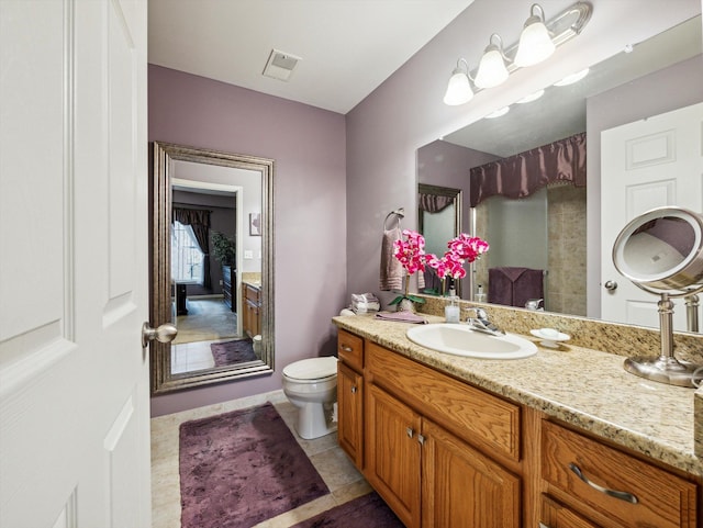 bathroom featuring tile patterned flooring, vanity, and toilet