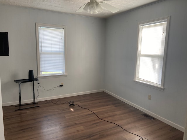 spare room featuring ceiling fan, wood-type flooring, and a textured ceiling