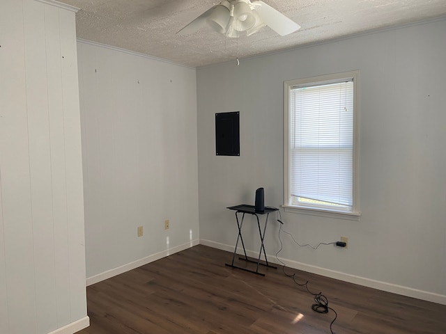 unfurnished room with a textured ceiling, electric panel, a healthy amount of sunlight, and dark hardwood / wood-style floors