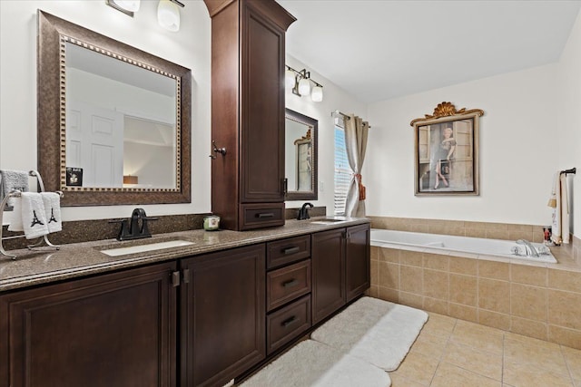 bathroom featuring tile patterned flooring, vanity, and tiled tub