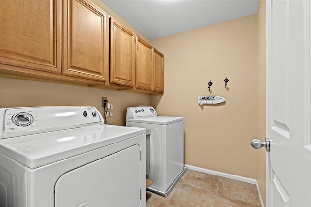 washroom with cabinets, light tile patterned floors, and washing machine and clothes dryer