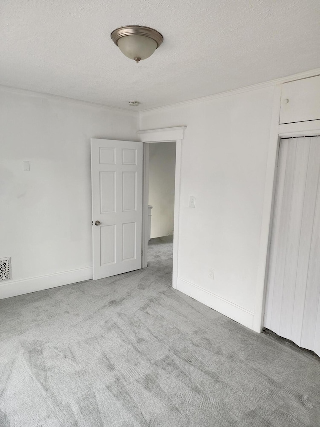 unfurnished bedroom featuring light colored carpet and a textured ceiling