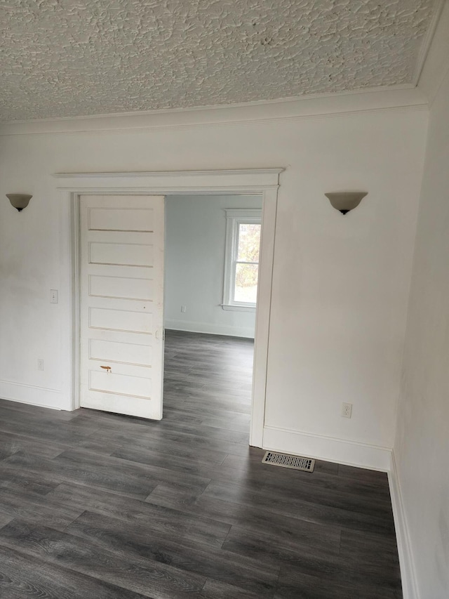 spare room with dark hardwood / wood-style flooring and a textured ceiling