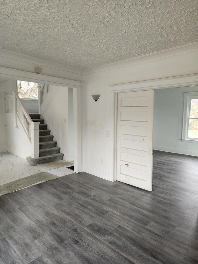 spare room featuring dark hardwood / wood-style flooring and a textured ceiling