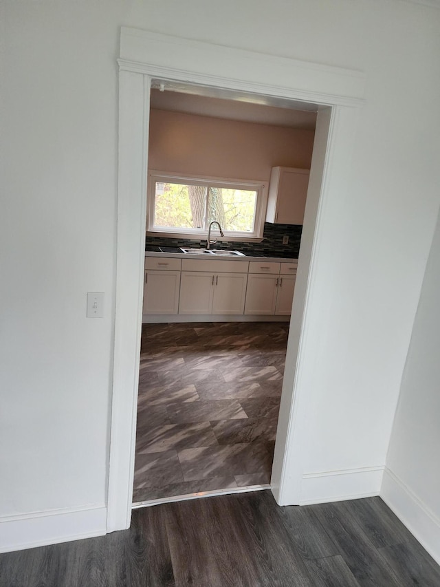 kitchen with backsplash, white cabinetry, sink, and dark hardwood / wood-style floors