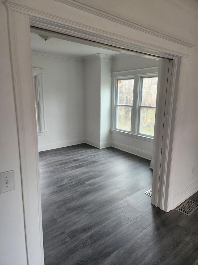 spare room featuring dark hardwood / wood-style floors and ornamental molding