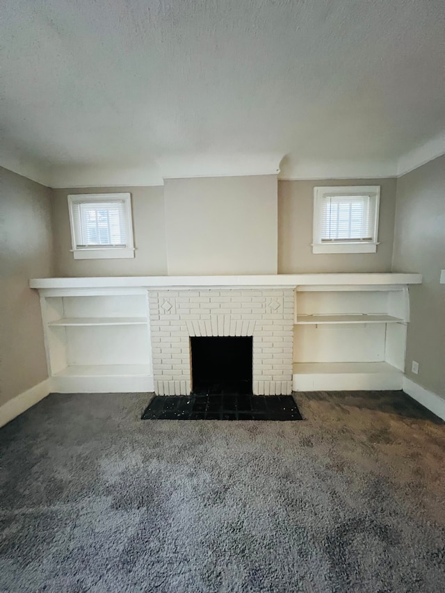 unfurnished living room featuring a wealth of natural light, a fireplace, and dark colored carpet