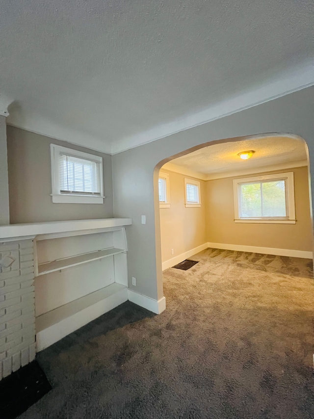 carpeted spare room featuring a textured ceiling