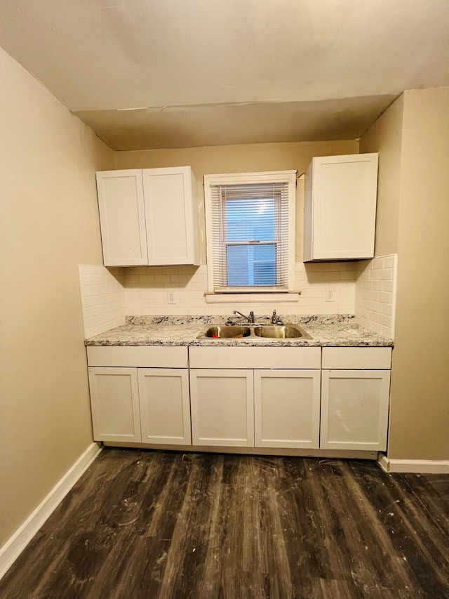 kitchen featuring backsplash, white cabinetry, dark wood-type flooring, and sink