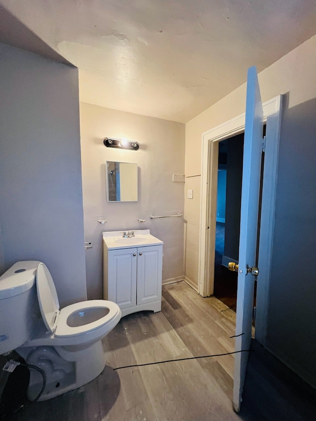 bathroom featuring vanity, wood-type flooring, and toilet