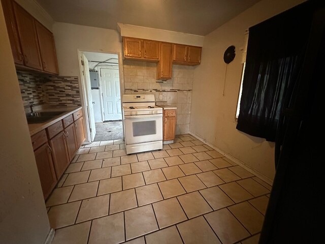 20511 Lyndon St, Detroit, MI 48223 - kitchen featuring white gas stove, a sink, decorative backsplash, light countertops, and light tile patterned flooring