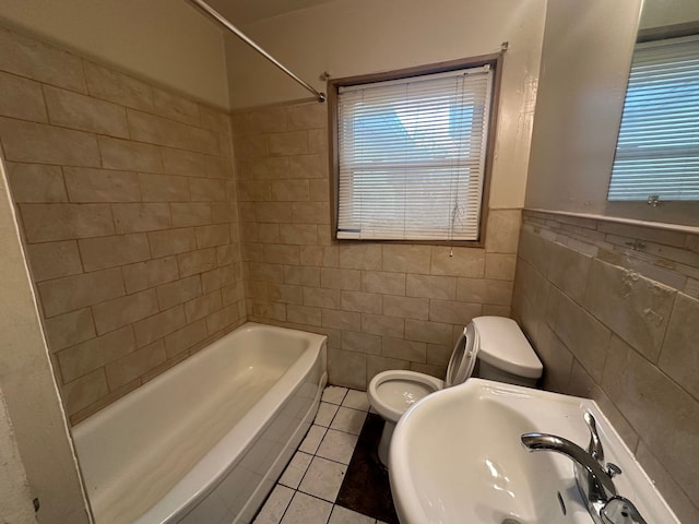 full bathroom featuring sink, tile walls, tile patterned flooring, toilet, and tiled shower / bath