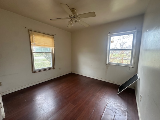 spare room with ceiling fan and dark hardwood / wood-style flooring