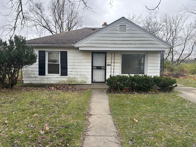 bungalow-style home with a front lawn