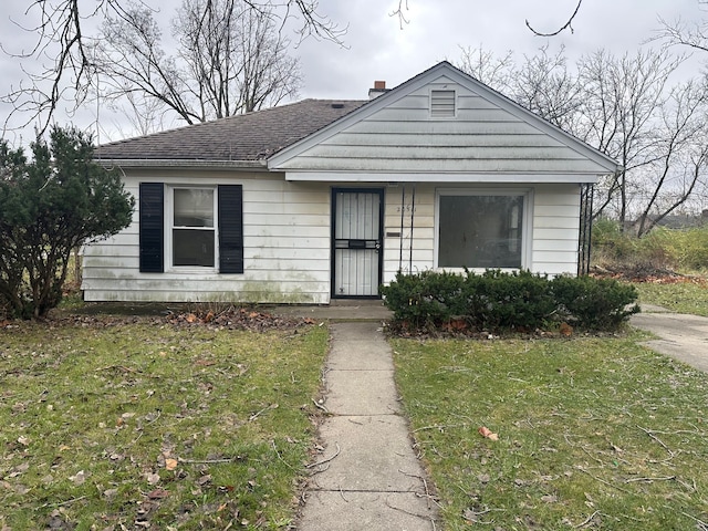20511 Lyndon St, Detroit, MI 48223 - bungalow with a front yard, a shingled roof, and a chimney