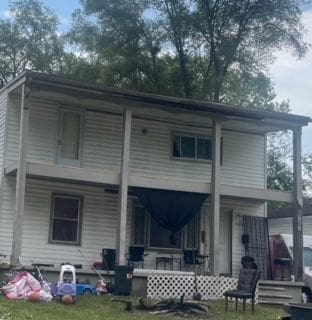 rear view of property with a lawn and covered porch