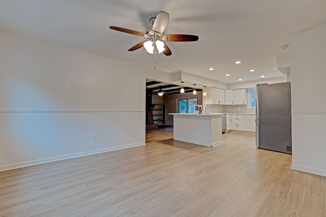 kitchen with decorative backsplash, stainless steel appliances, ceiling fan, light hardwood / wood-style flooring, and white cabinets