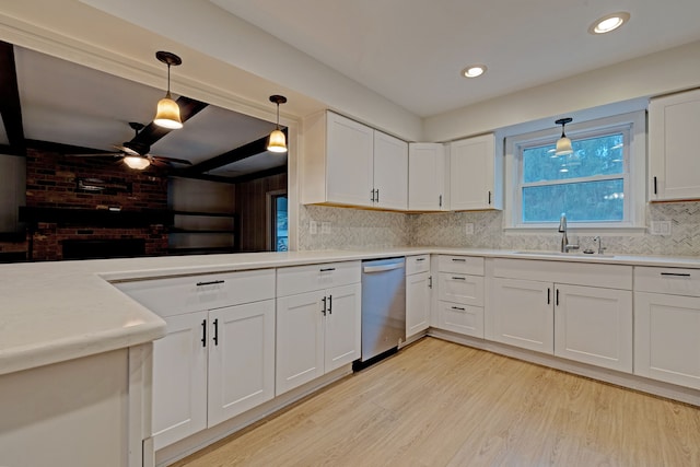 kitchen featuring white cabinetry, sink, hanging light fixtures, stainless steel dishwasher, and light wood-type flooring