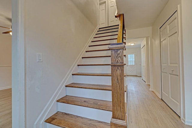 staircase with hardwood / wood-style flooring and ceiling fan