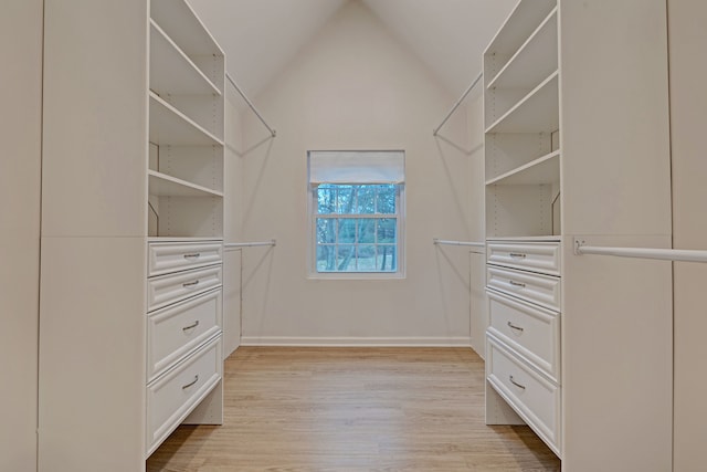 spacious closet with light hardwood / wood-style floors and lofted ceiling