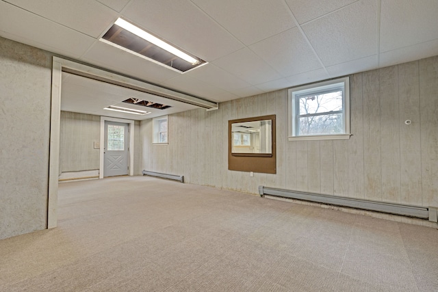 basement with a wealth of natural light, carpet floors, and a baseboard radiator