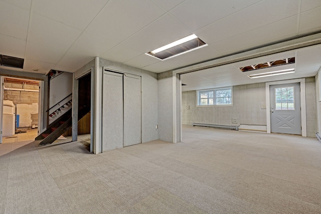 basement featuring light colored carpet and a baseboard radiator