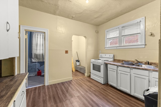 kitchen with radiator, sink, dark wood-type flooring, white electric stove, and butcher block countertops