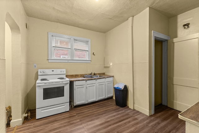 kitchen featuring white range with electric cooktop, sink, white cabinetry, and dark wood-type flooring