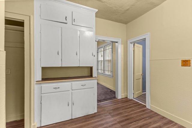 kitchen featuring white cabinetry, a textured ceiling, and hardwood / wood-style flooring