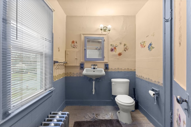 bathroom featuring sink, tile walls, and toilet