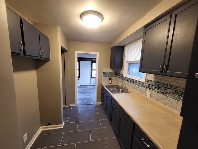 20501 Elkhart St, Harper Woods, MI 48225 - kitchen featuring a sink, baseboards, tasteful backsplash, dark tile patterned flooring, and light countertops