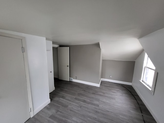 bonus room with hardwood / wood-style flooring and vaulted ceiling