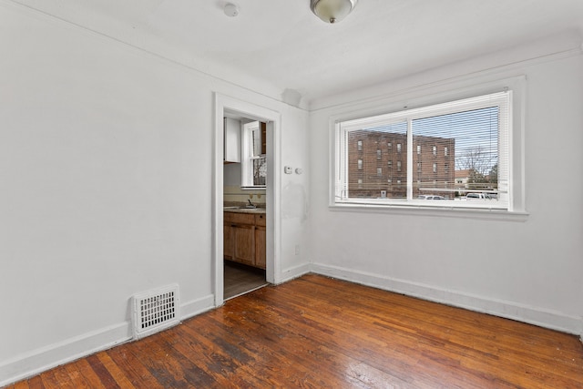 unfurnished bedroom with dark hardwood / wood-style floors and ensuite bath