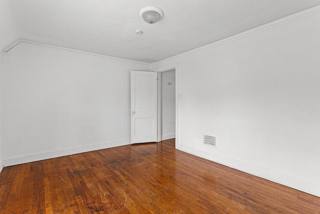 empty room with crown molding, lofted ceiling, and hardwood / wood-style flooring