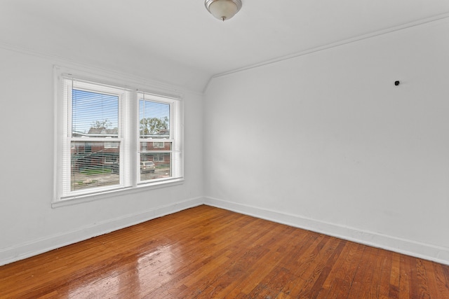 unfurnished room with hardwood / wood-style floors and lofted ceiling