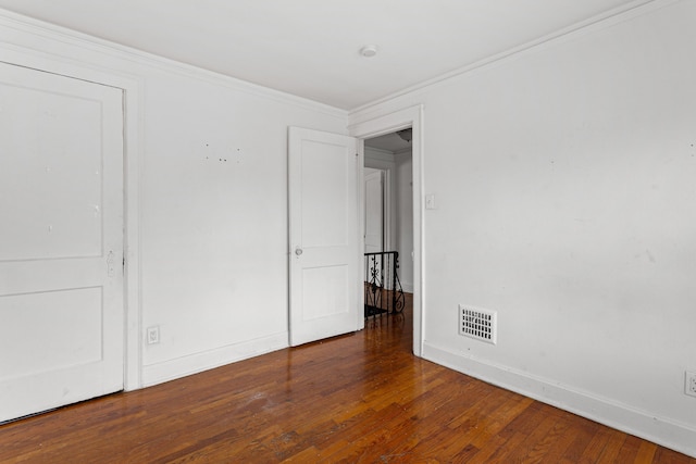 unfurnished bedroom with dark hardwood / wood-style flooring and ornamental molding