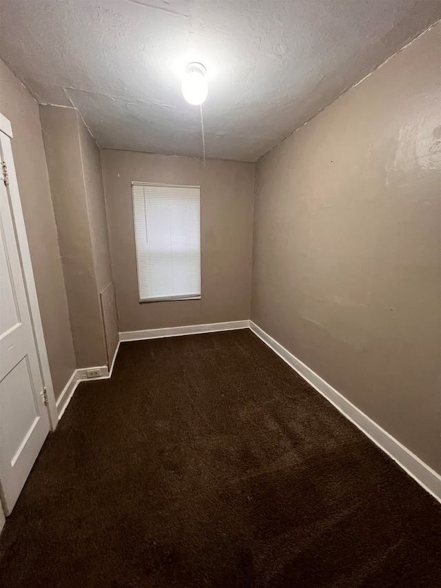 carpeted empty room featuring a textured ceiling