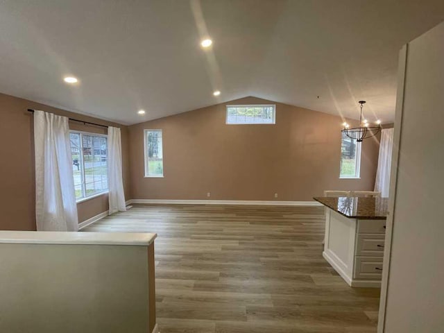 interior space with plenty of natural light, light wood-type flooring, and vaulted ceiling